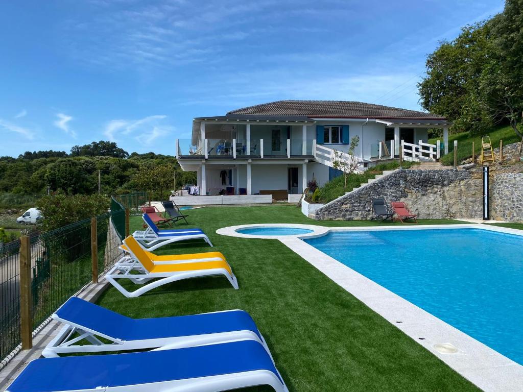 uma casa com piscina ao lado de uma casa em I LOVE ISLA PLAYA (SOLO FAMILIAS) em Isla