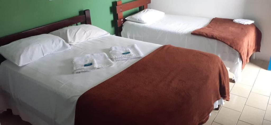 two beds with towels on them in a bedroom at Hotel da Ilha Comprida in Ilha Comprida