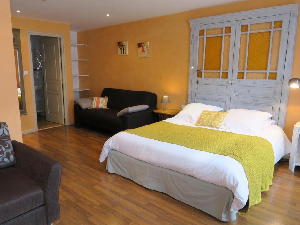 - une chambre avec un grand lit et une chaise dans l'établissement Chambres du Petit Bois, à Charleville-Mézières