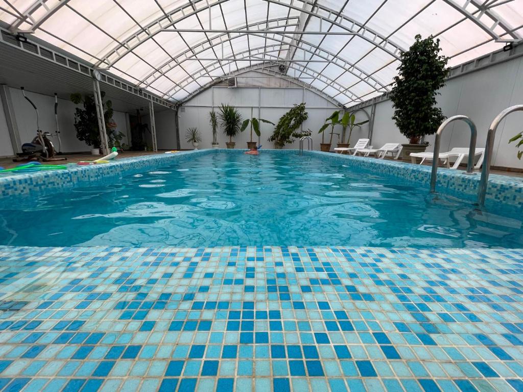 a large swimming pool with a glass ceiling at Дом отдыха Предгорье in Khadyzhensk