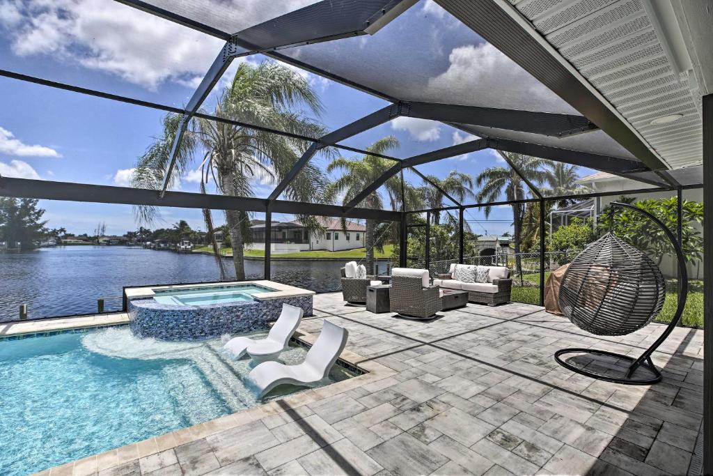 a swimming pool with a patio with a view of the water at Canal-Front Cape Coral Home: Pool & Patio in Cape Coral