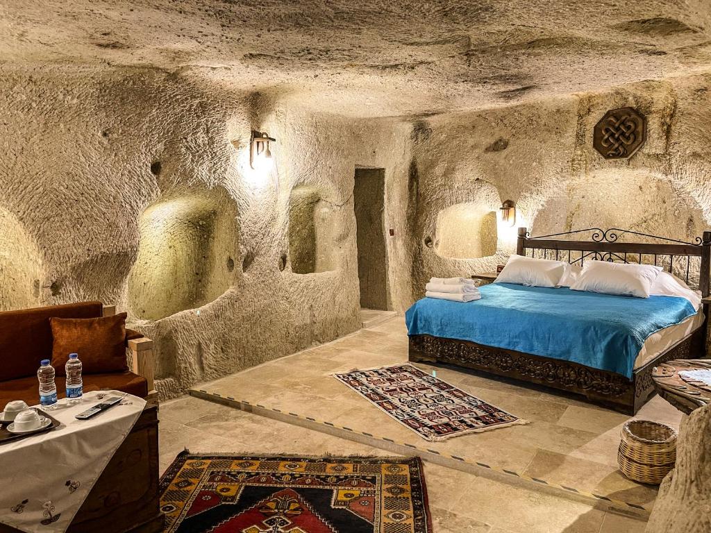 a bedroom with a bed in a stone room at Takunya Cave Hotel in Nevşehir