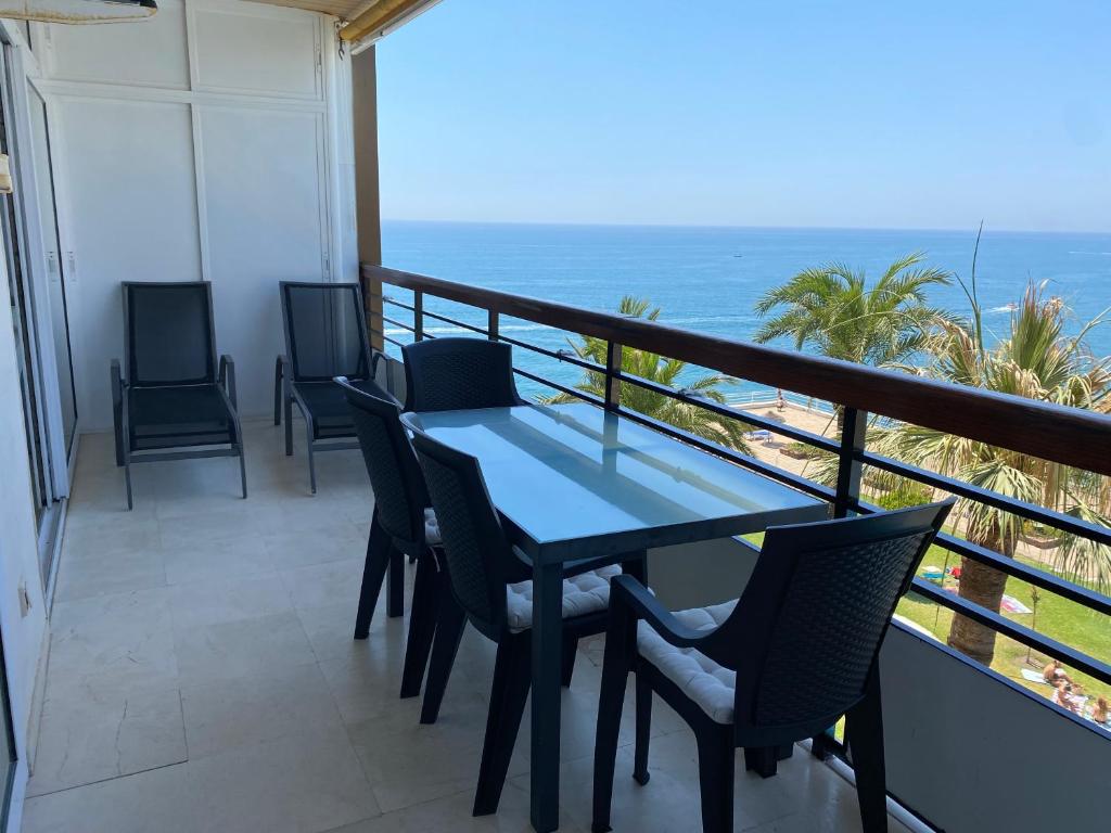 balcón con mesa, sillas y vistas al océano en Castillo de Santa Clara 3 en Torremolinos