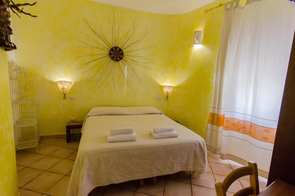 ein Schlafzimmer mit einem Bett mit zwei Handtüchern darauf in der Unterkunft La Pavoncella in Tortolì