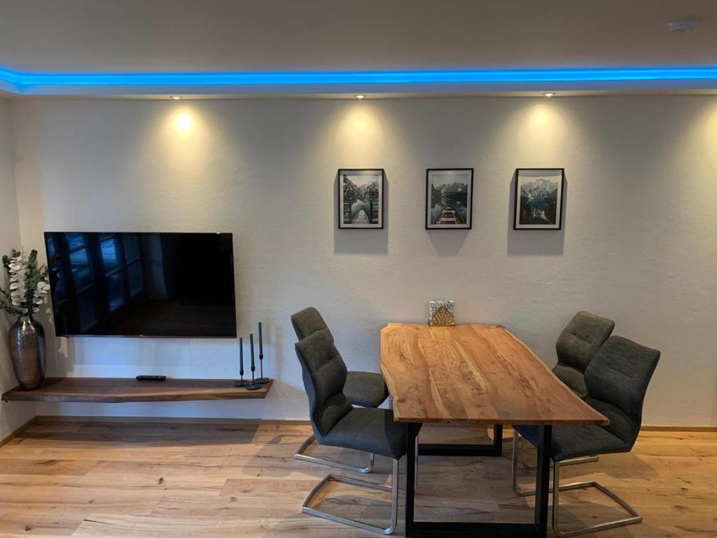 a dining room with a table and a tv at Ferienwohnung Räsl in Holzkirchen