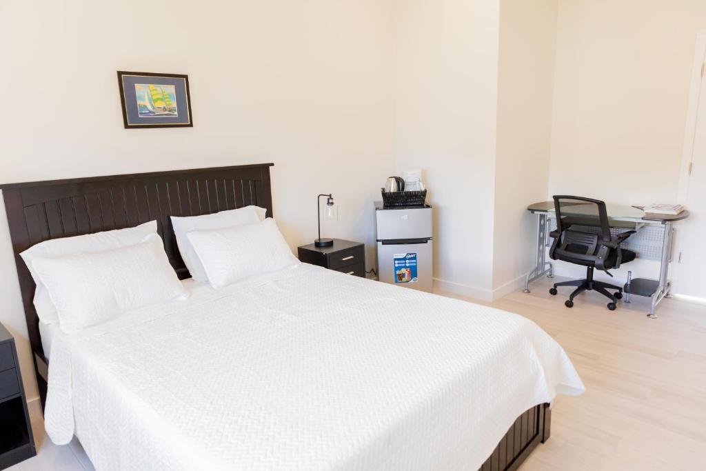 
a bedroom with a bed and a desk at Addison Lee Cayman Villa in George Town
