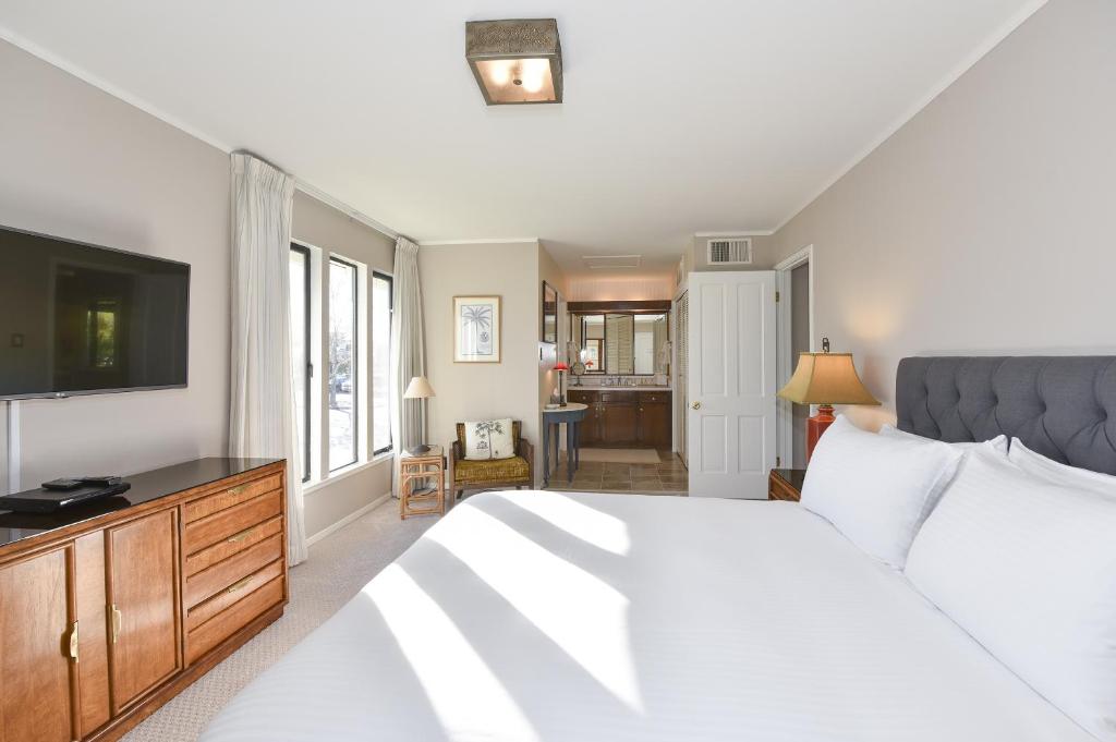 a bedroom with a large white bed and a flat screen tv at 305 Northgate at Silverado in Napa condo in Napa