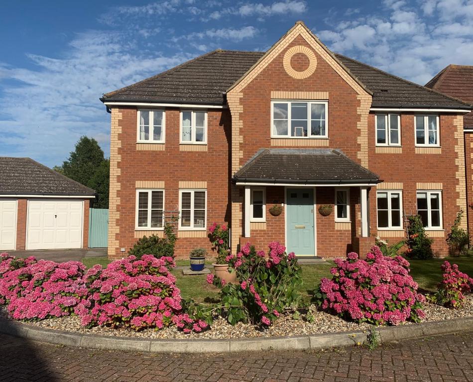 a brick house with pink flowers in front of it at Willow Farm Way in Herne Bay