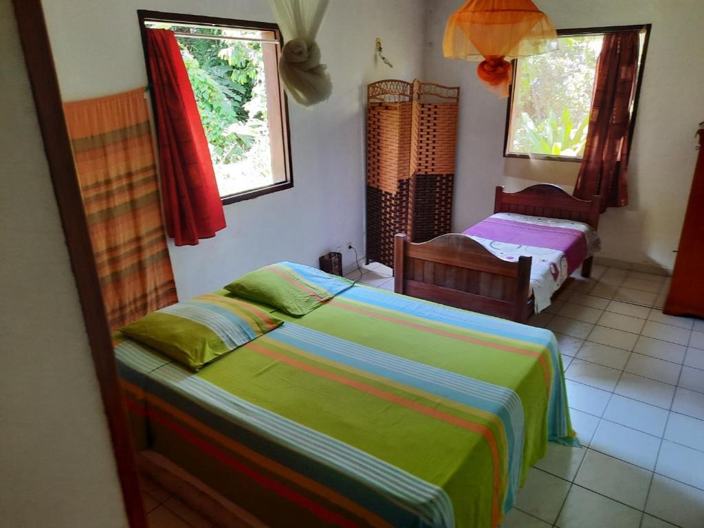 una camera da letto con due letti e due finestre di Peaceful House a Vieux-Habitants