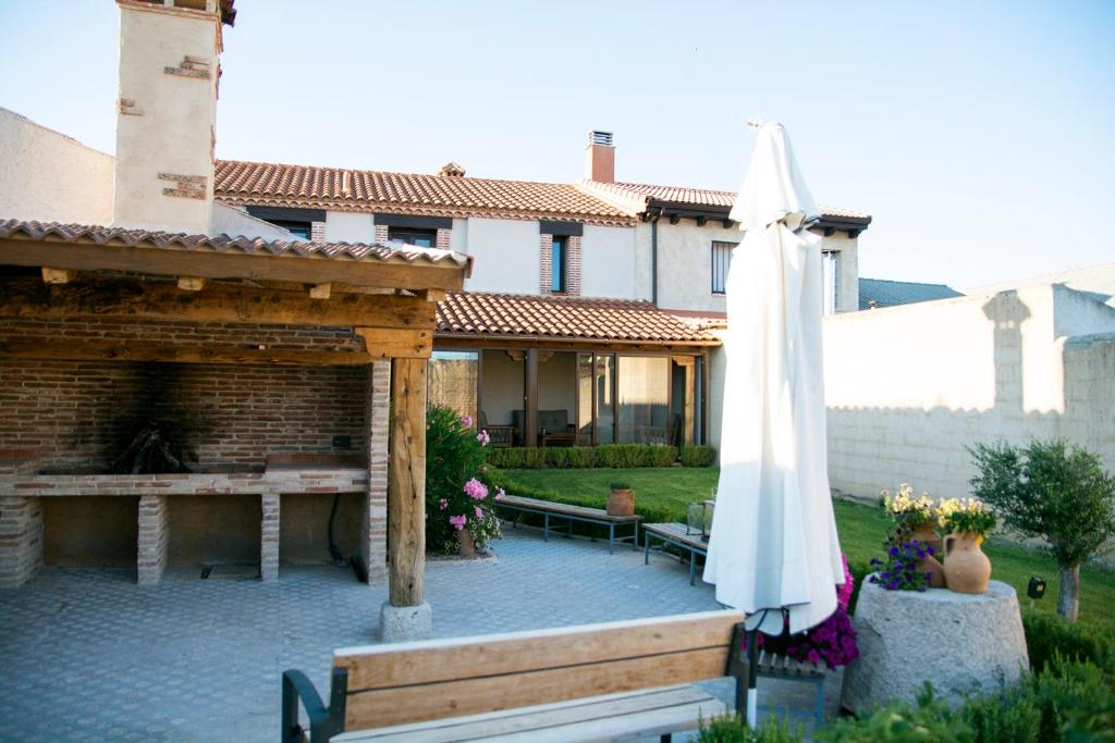 un patio con ombrellone e tavolo e un edificio di Casa Rural Zacarías a Sardón de Duero