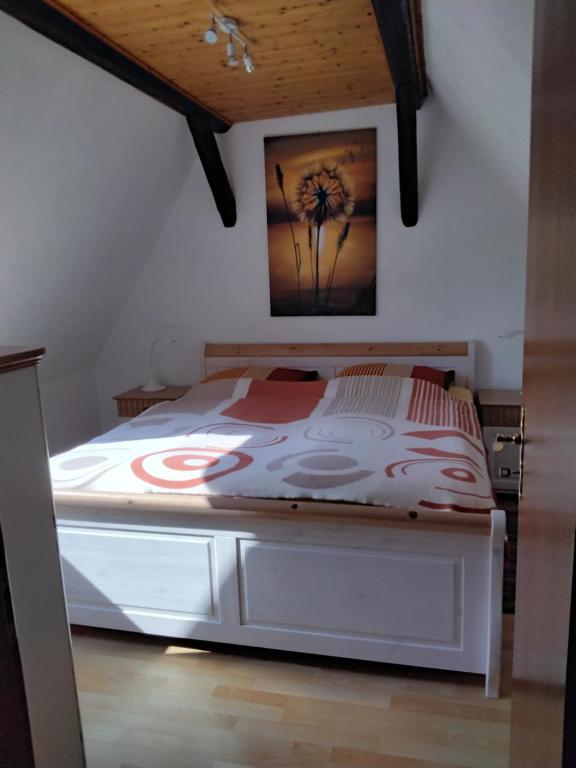 ein Schlafzimmer mit einem Bett mit einem Blumenbild an der Wand in der Unterkunft Pusteblume in Groitzsch