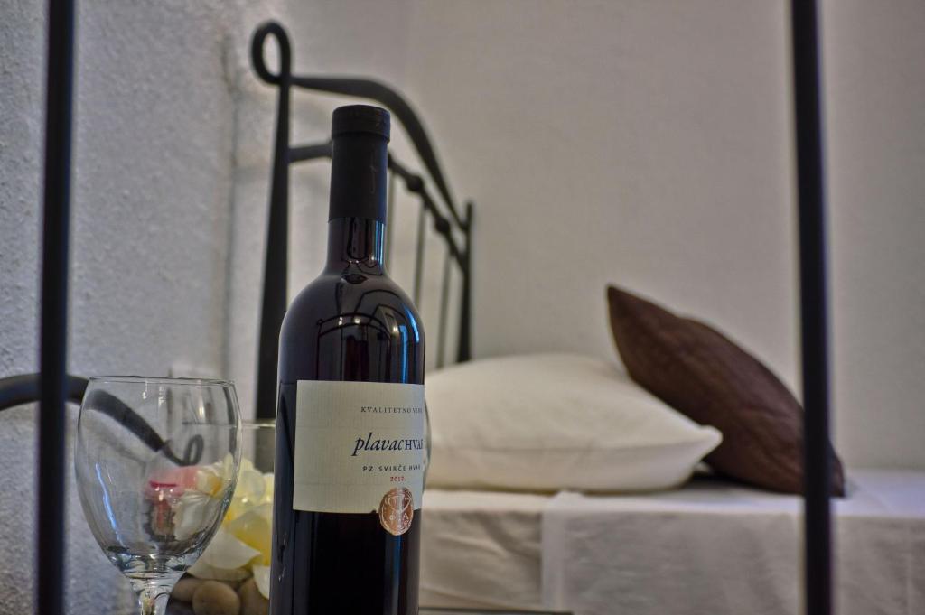 butelkę wina i kieliszek na stole w obiekcie Studio Šime w Splicie