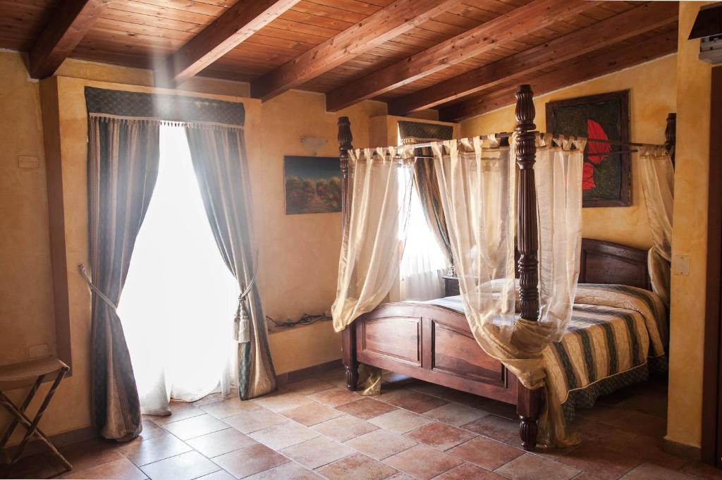 a bedroom with a canopy bed and two windows at Locanda Dei Baroni in Vasto