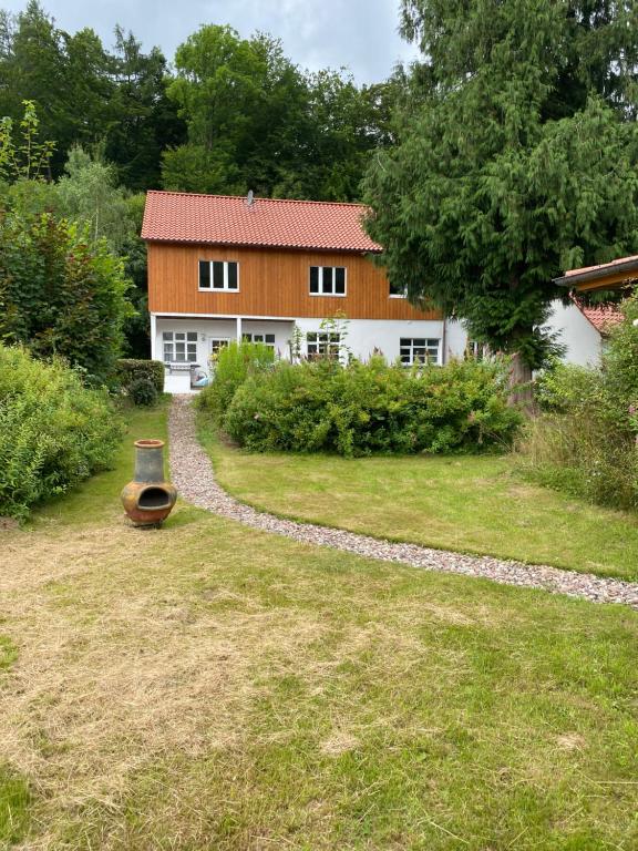 a house with a stone path in front of a yard at Ferien Langer Grund mitten im Wald in Bad Pyrmont