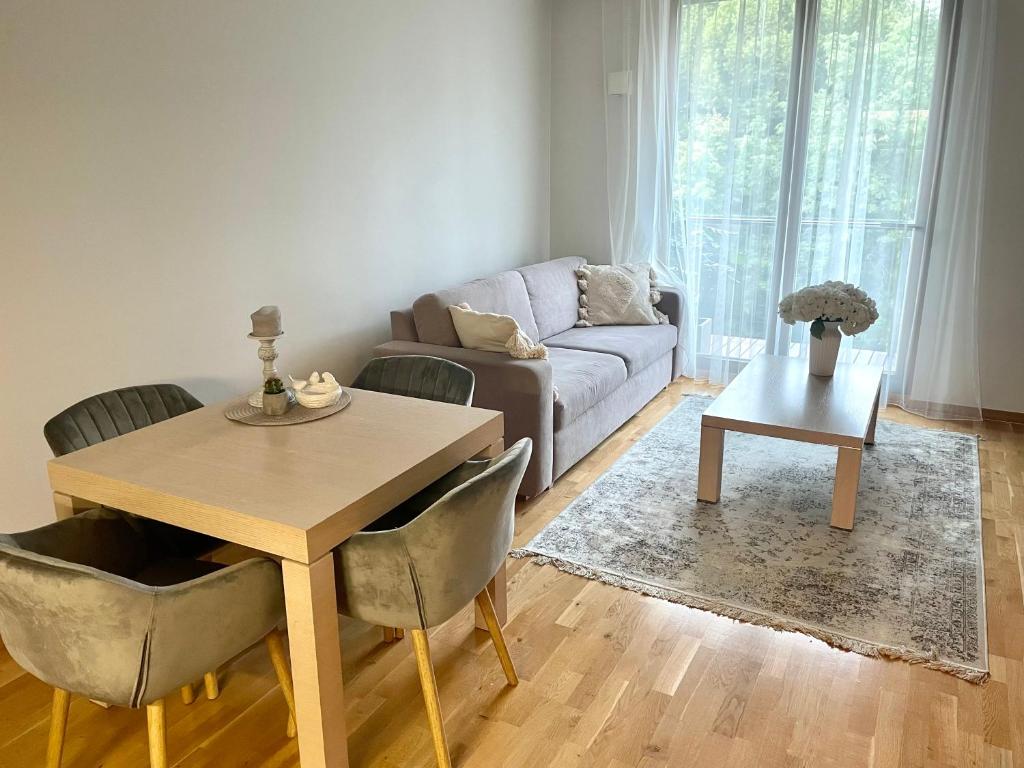 ein Wohnzimmer mit einem Tisch und einem Sofa in der Unterkunft Küüni Guest Apartment in Tartu