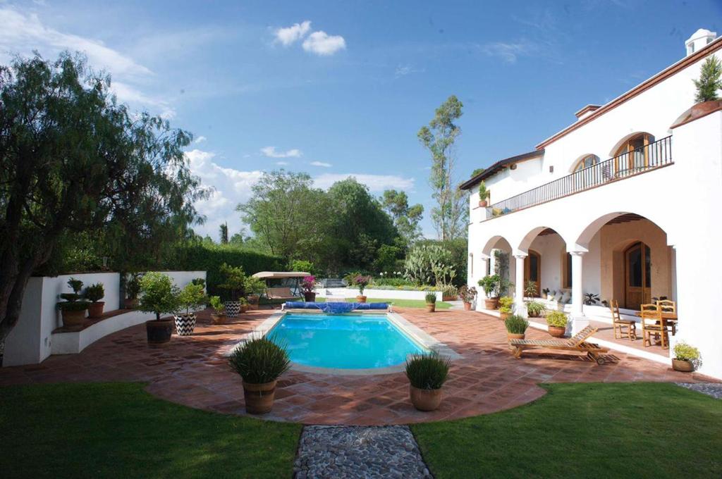 a house with a swimming pool in the yard at La Casona de los Colibríes in Villa del Pueblito