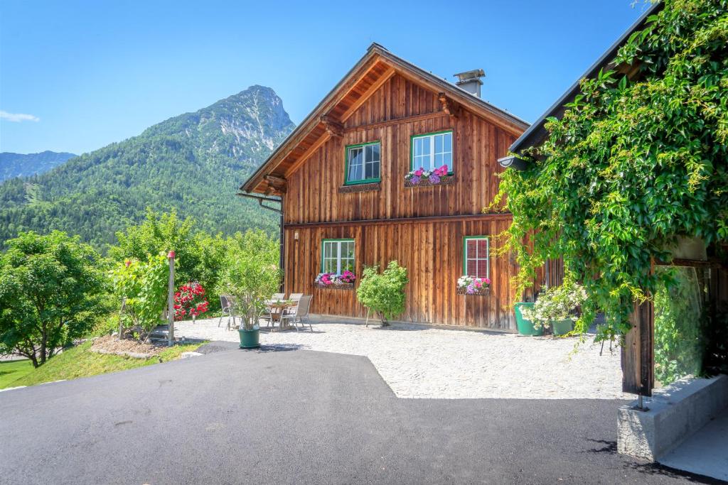 a wooden house with mountains in the background at Lovely house with mountain view & big garden in Bad Aussee in Bad Aussee