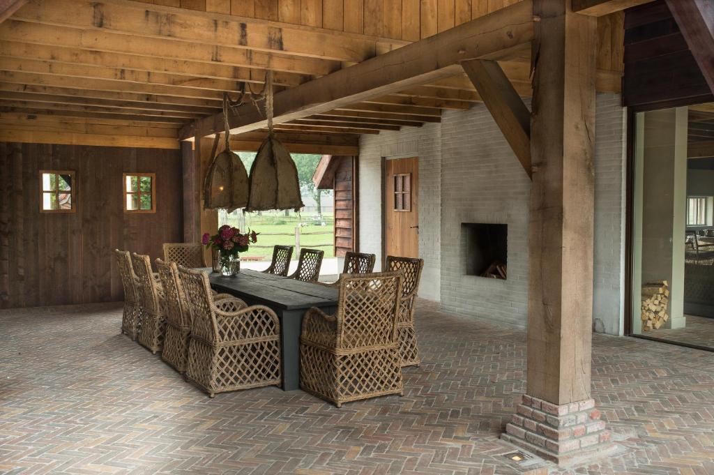 um pátio com uma mesa e cadeiras e uma lareira em Erve Jonkerhoeve em Heesch
