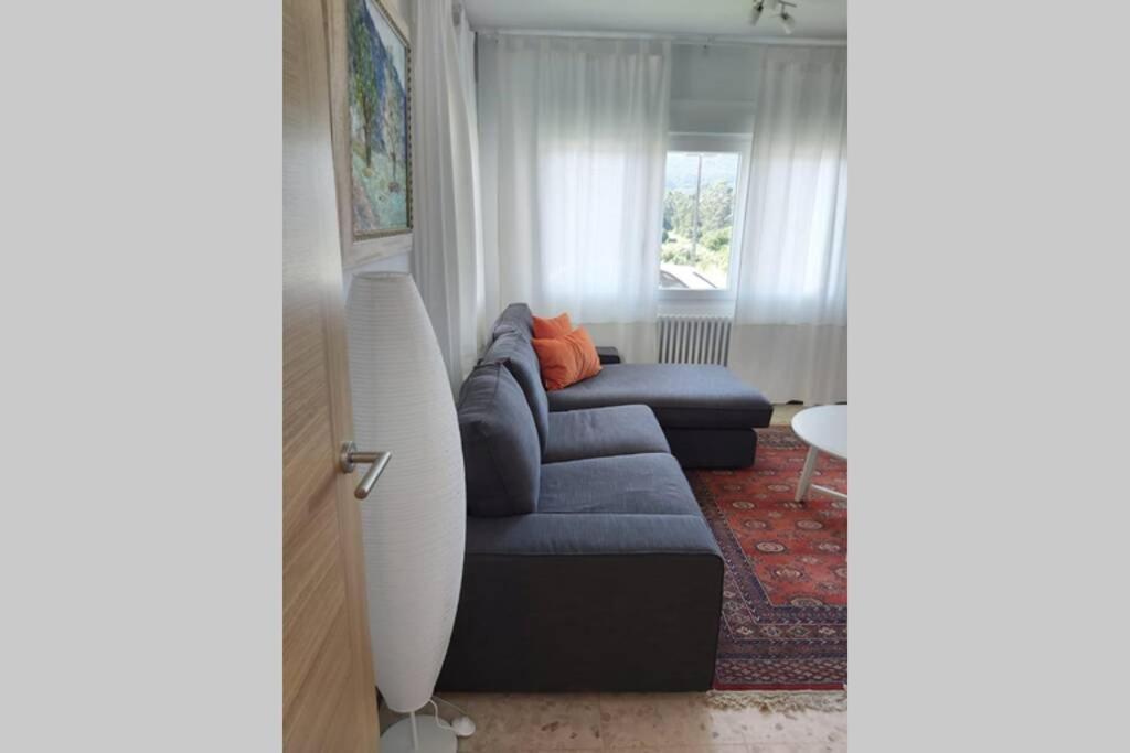 a living room with a blue couch and a window at Chalet Meu Lar in O Casal Pontevedra