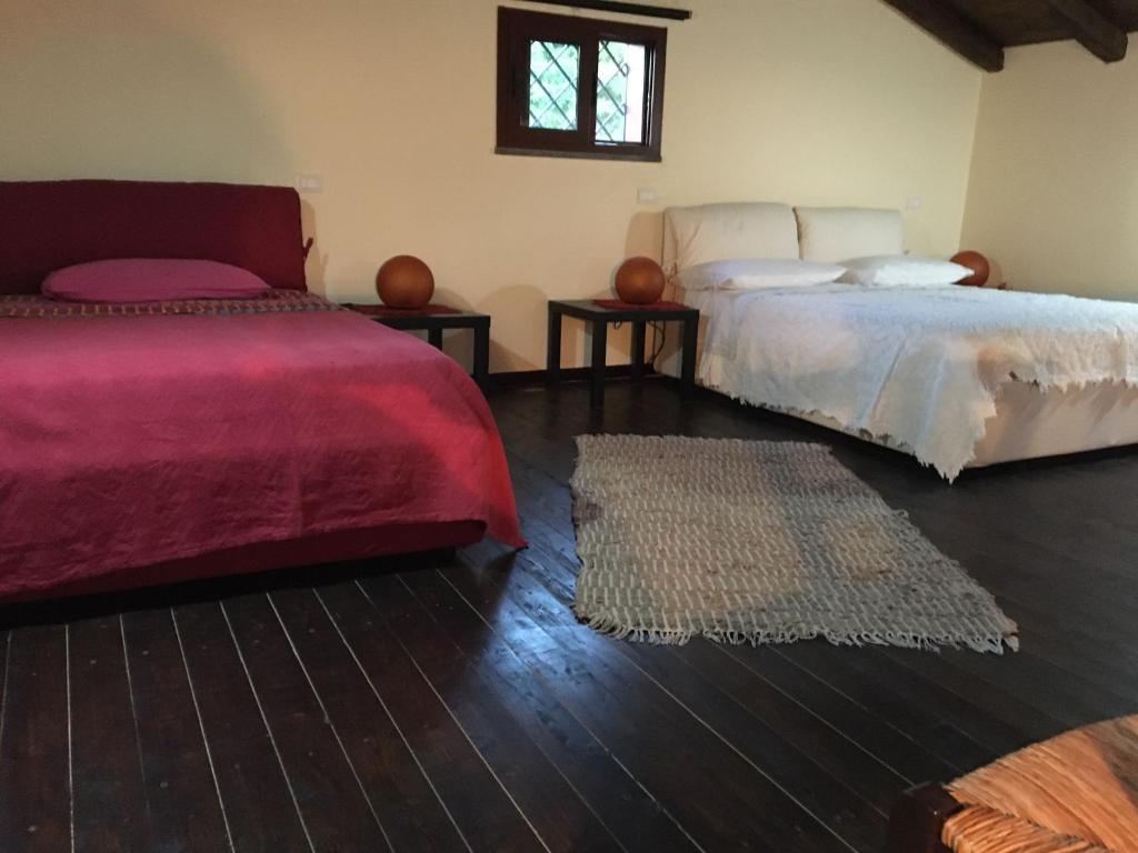 a bedroom with two beds and a rug at Chalet Etna in Biancavilla