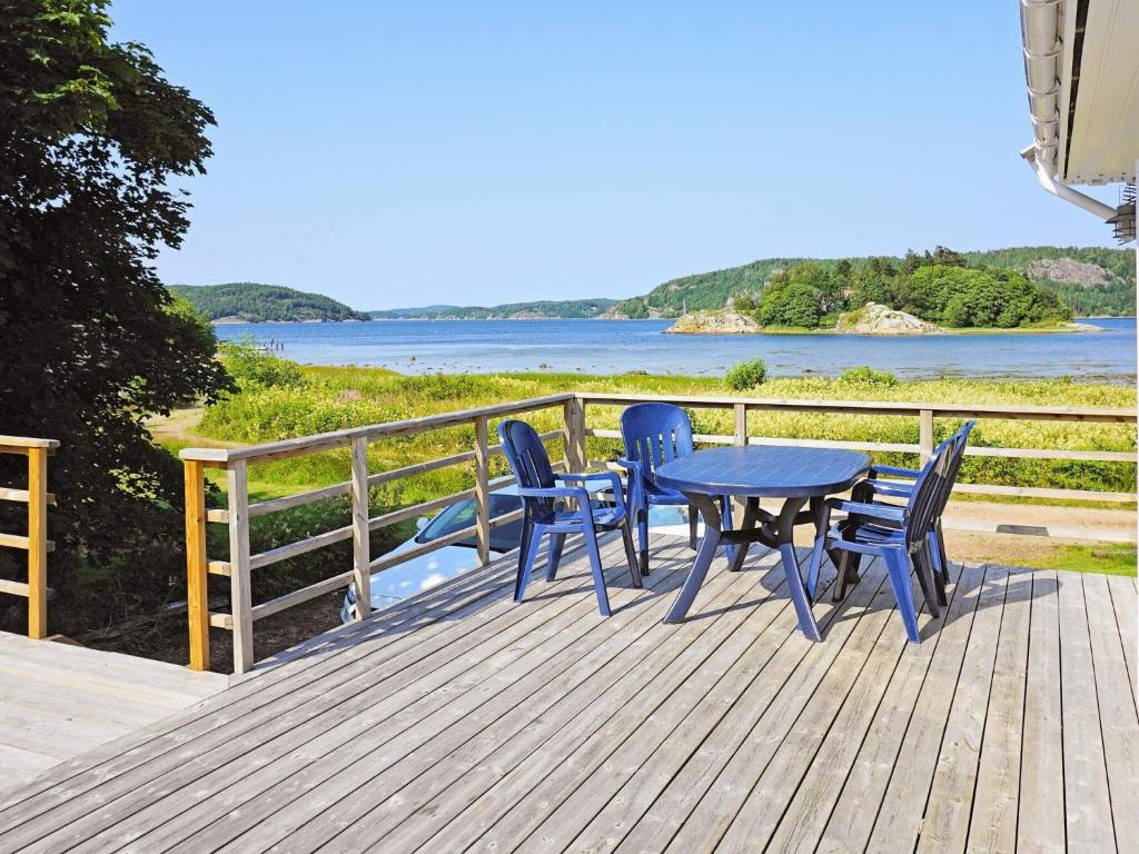 Henånにある4 person holiday home in HEN Nのテーブルと椅子が備わるデッキから水辺の景色を望めます。