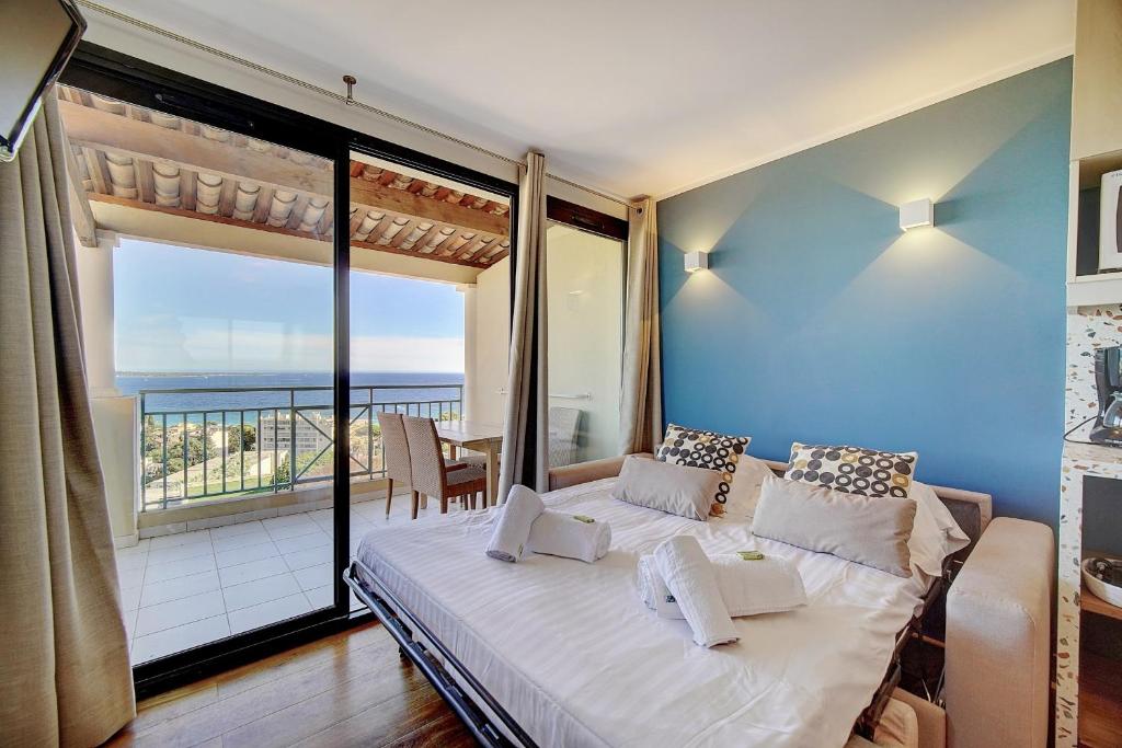 Schlafzimmer mit einem großen Bett und Meerblick in der Unterkunft IMMOGROOM Cosy Modern Sea view Terrace AC Parking - CONGRESSBEACHES in Cannes