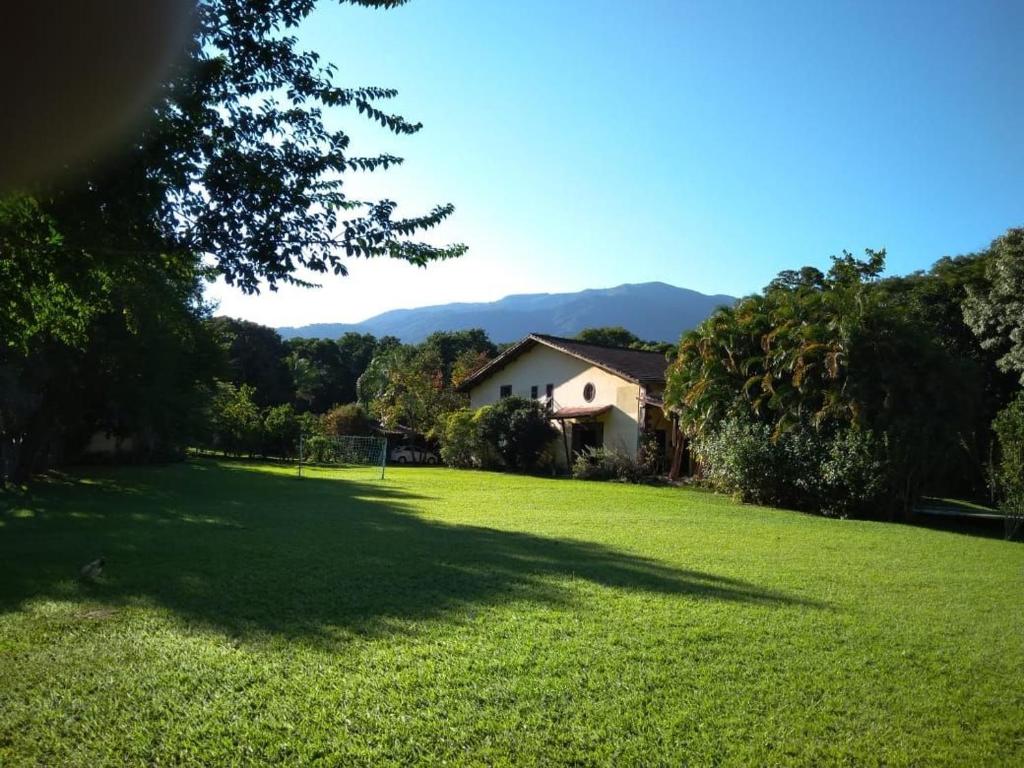 a house in the middle of a grassy yard at Pousada Serra da Mantiqueira in Bom Sucesso