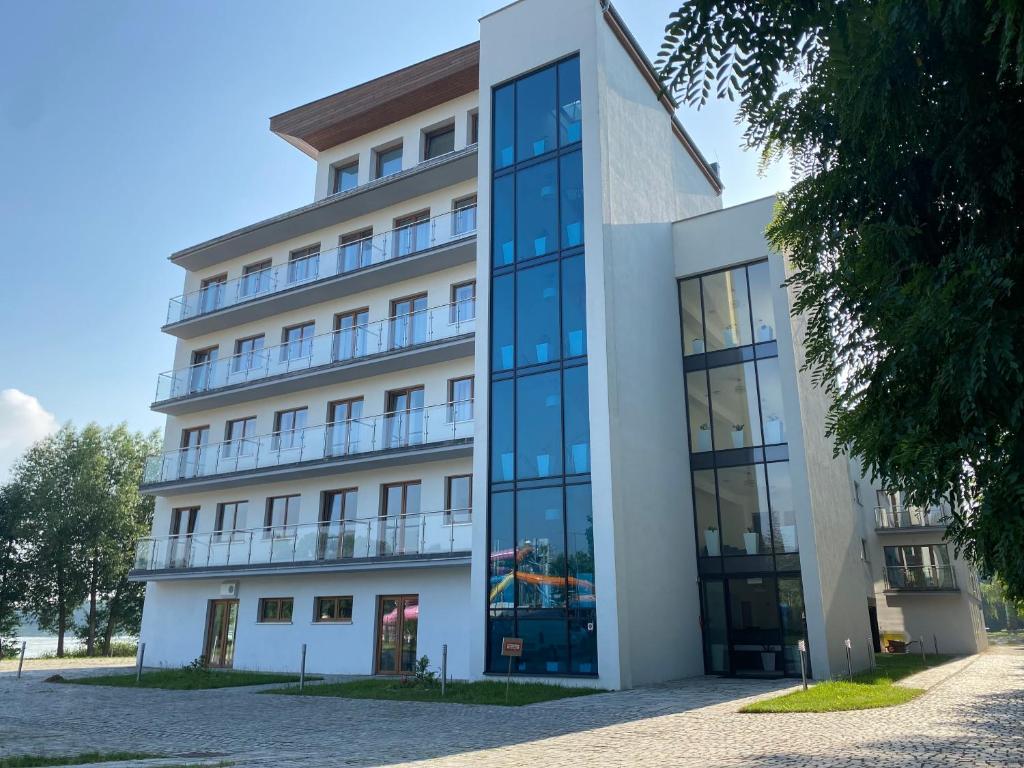 a large white building with glass windows at Rezydencja Margonin in Margonin