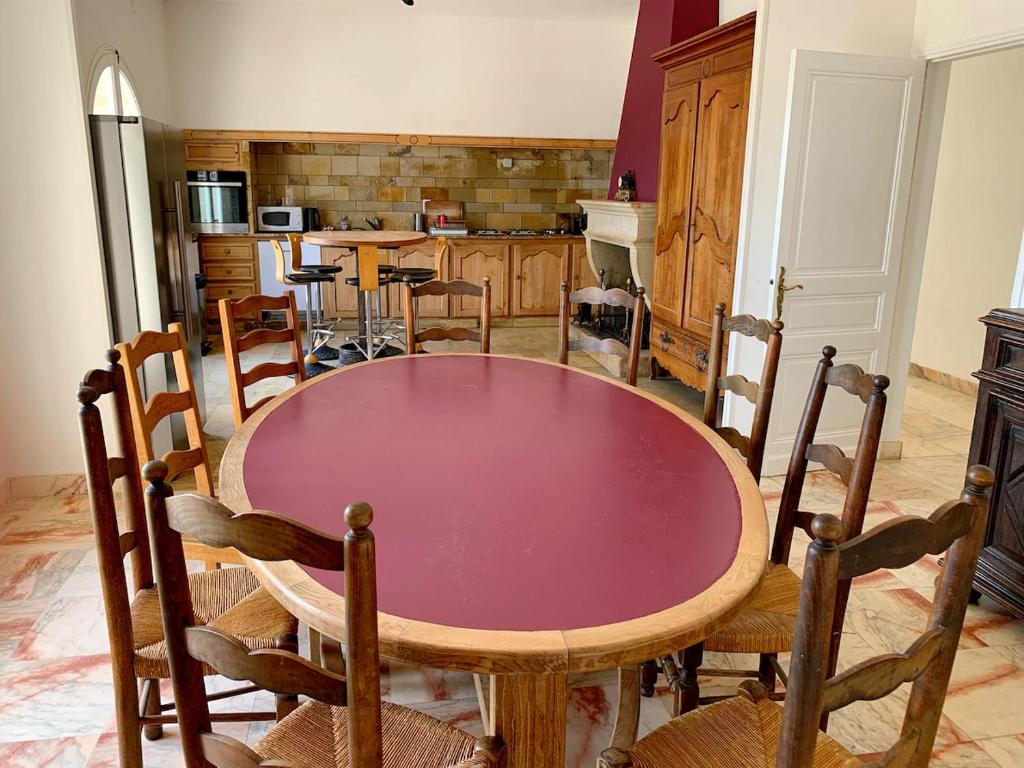 a kitchen with a table and chairs in a room at Magnifique villa de charme avec piscine in Casteljaloux