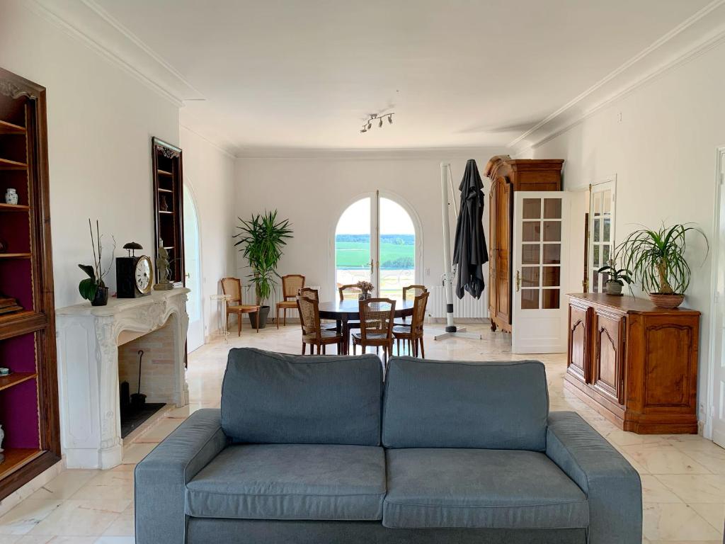 a living room with a couch and a table at Magnifique villa de charme avec piscine in Casteljaloux