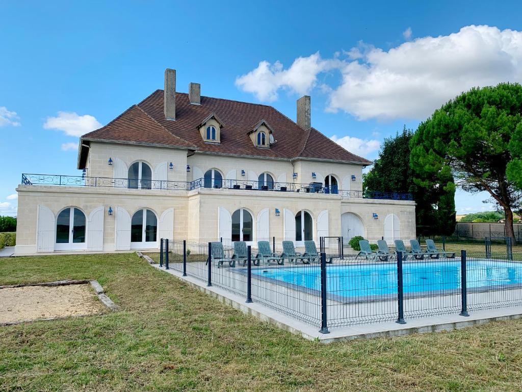 a large house with a swimming pool in front of it at Magnifique villa de charme avec piscine in Casteljaloux