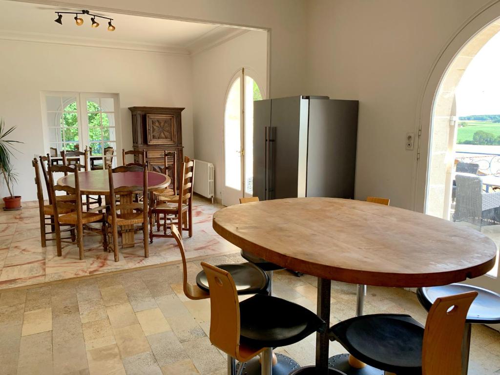 a kitchen and dining room with a table and chairs at Magnifique villa de charme avec piscine in Casteljaloux