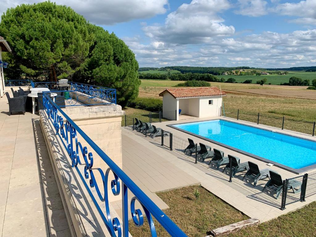 a swimming pool with chairs next to a fence at Magnifique villa de charme avec piscine in Casteljaloux