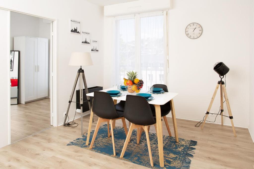 une salle à manger avec une table, des chaises et une horloge dans l'établissement LA MAISON DU BONHEUR, à Rouen