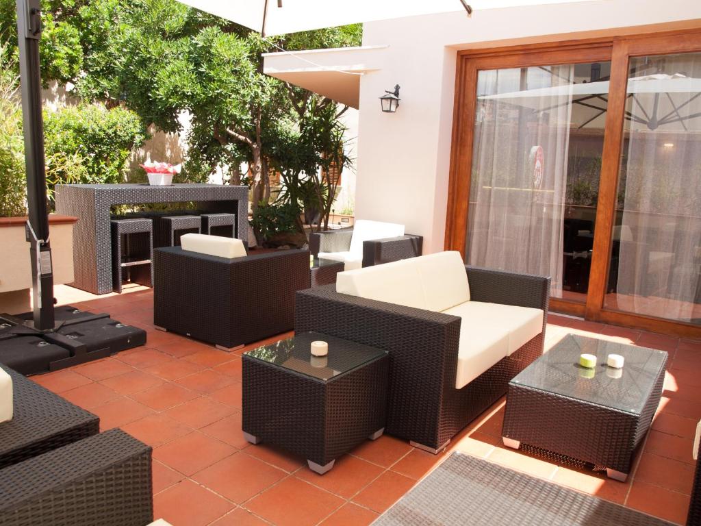 a patio with wicker furniture and a fireplace at Hotel Garibaldi in La Maddalena