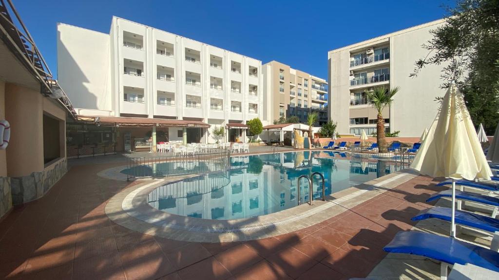 a swimming pool in front of a hotel at Oya Family Suites in Kusadası