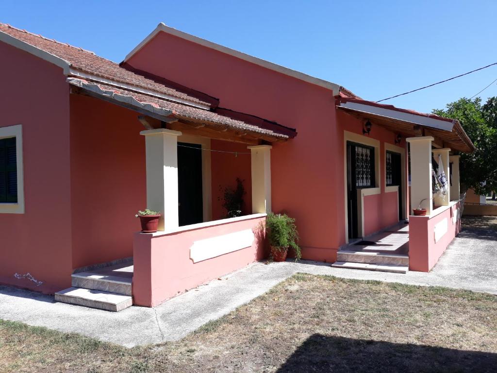 une maison avec une maison rouge dans l'établissement Aggeliki Apartments, à Sidari