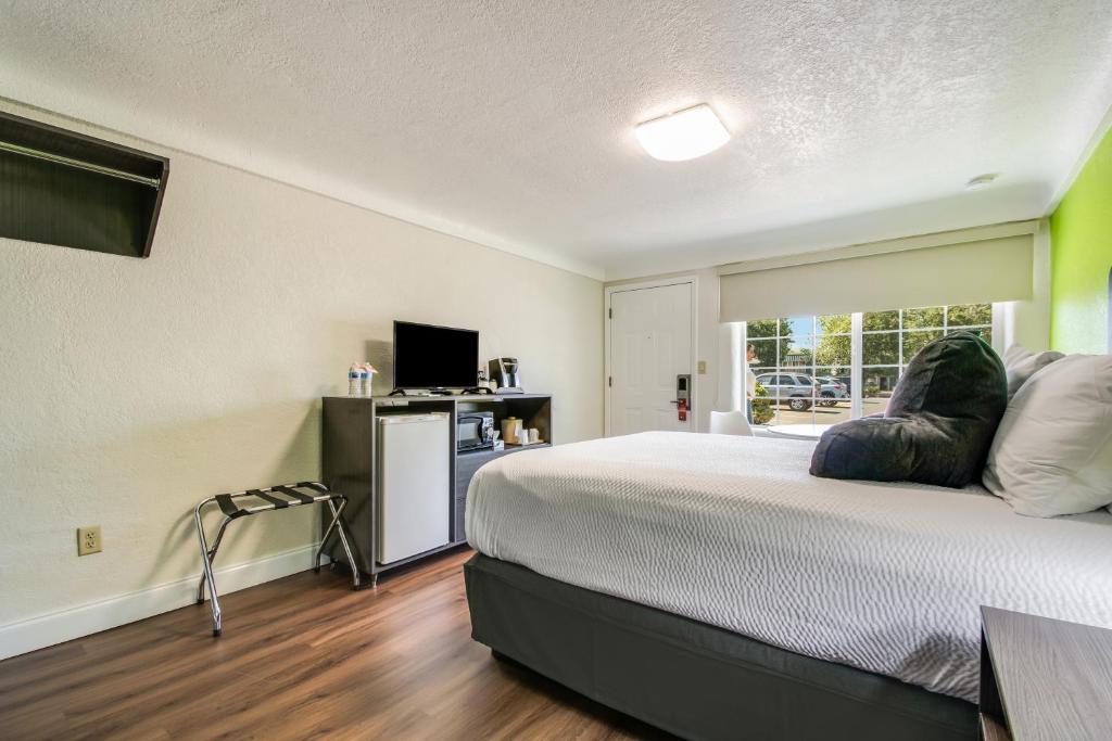 a bedroom with a large bed with a window at Signature Inn Eugene in Eugene