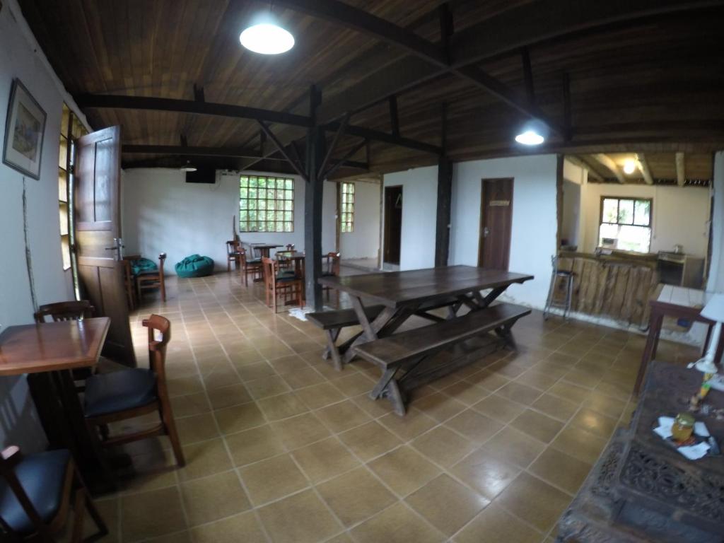 Habitación grande con mesa de madera y sillas. en Gran Camping Cabanas da Fazenda en Visconde De Maua