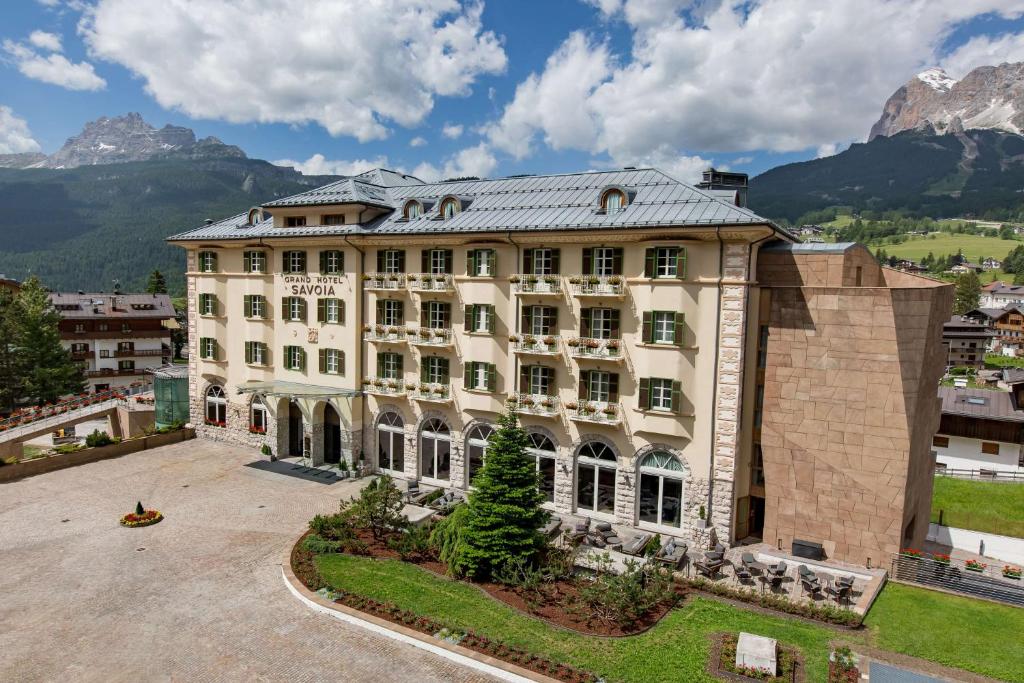 una vista aerea di un edificio con montagne sullo sfondo di Grand Hotel Savoia Cortina d'Ampezzo, A Radisson Collection Hotel a Cortina dʼAmpezzo
