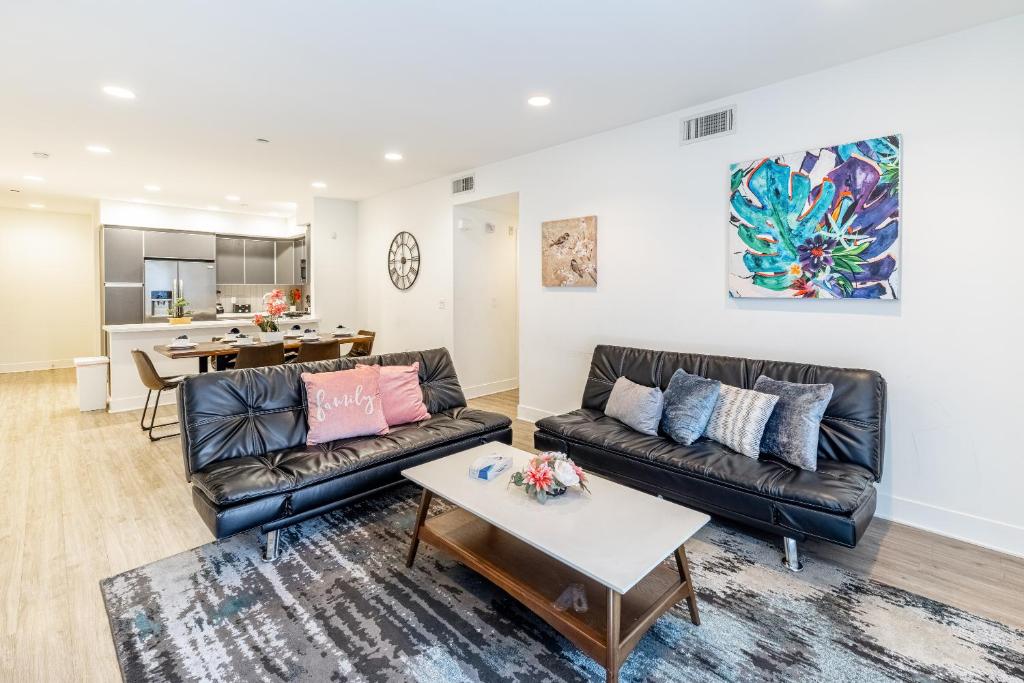 a living room with two leather couches and a table at Heaven on Hollywood Furnished Apartments in Los Angeles