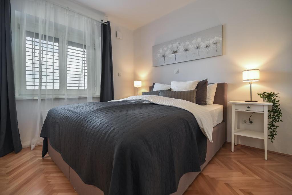 ein Schlafzimmer mit einem großen Bett und einem Fenster in der Unterkunft Lagom apartment Maribor w free parking & WiFi, tourist TAX included in Maribor
