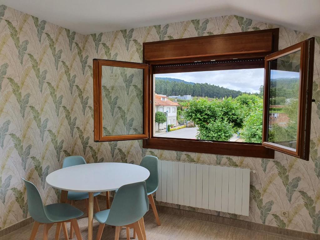 Pokój ze stołem, krzesłami i oknem w obiekcie Apartamento A casa da feira w mieście Pontevedra