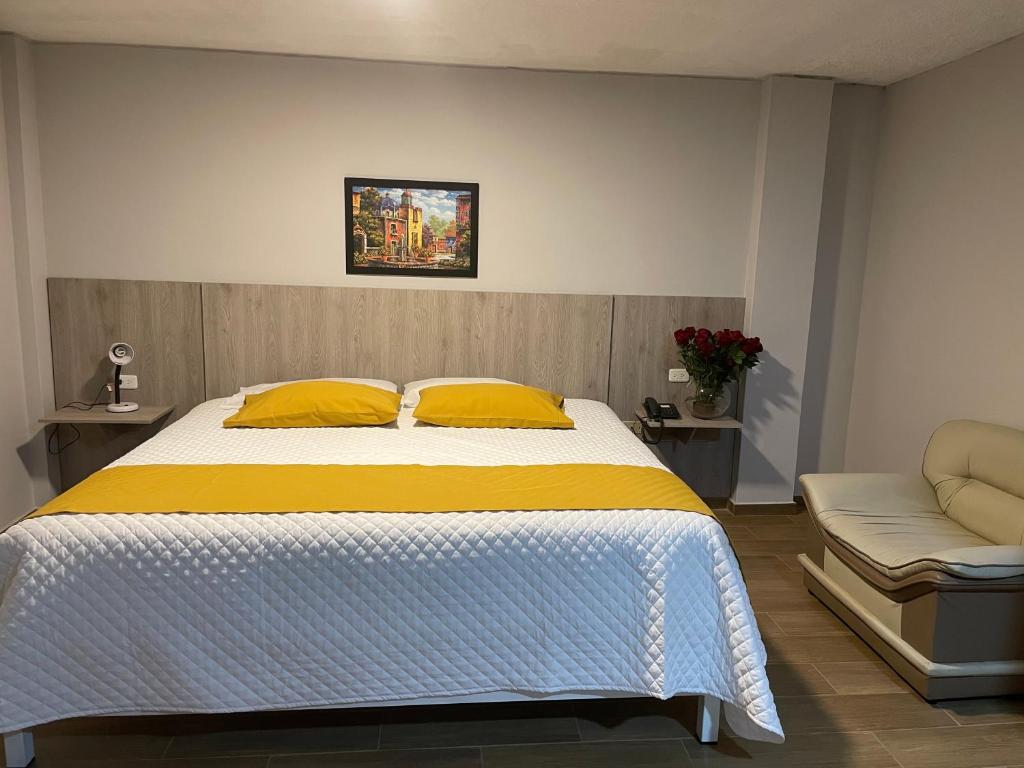a bedroom with a bed with yellow pillows and a chair at Terraza Dreams in Quito