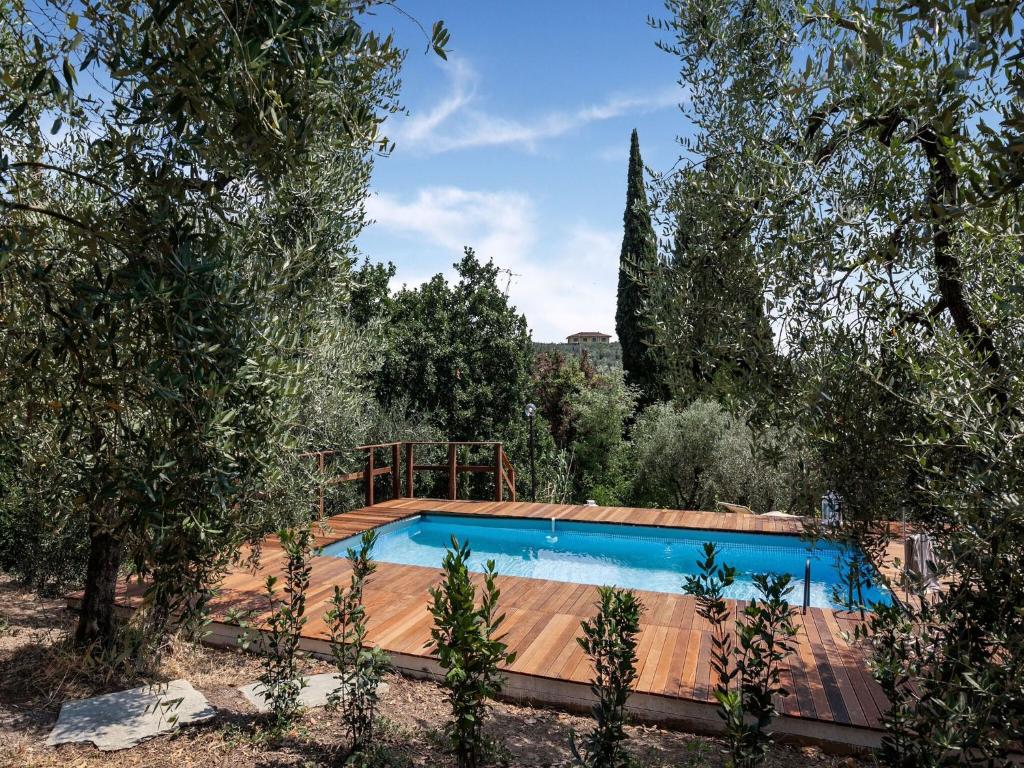 uma piscina num jardim com árvores em Belvilla by OYO Villa Rose em Cecina