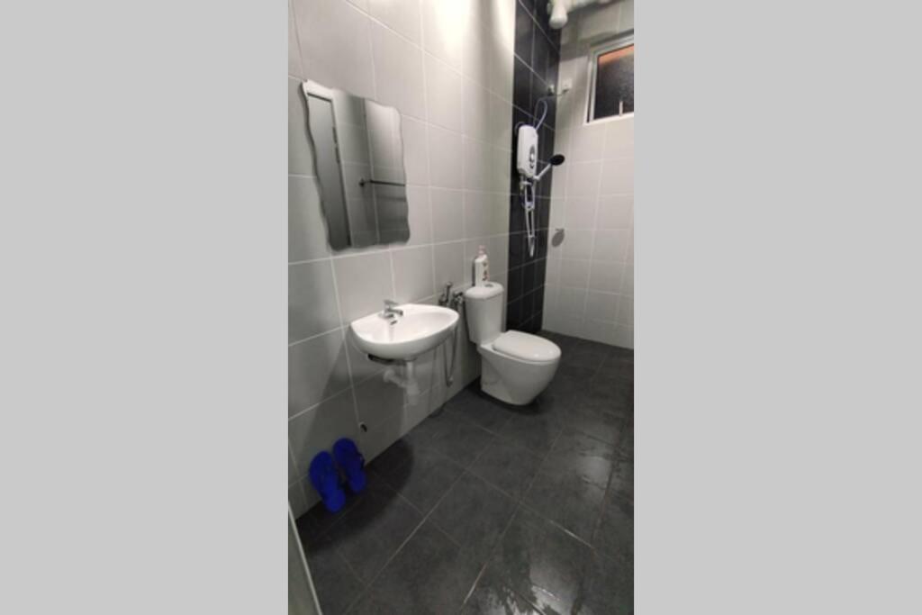 un baño con inodoro y lavabo en Pangsapuri Ladang Tanjung, en Kuala Terengganu