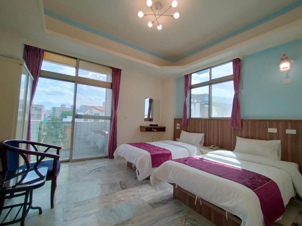 Duas camas num quarto com uma janela grande em 陶陶居商旅 Tautauchu Hotel em Hualien City