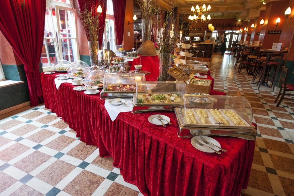 a buffet line with red tables with food on them at XII Apostel Albergo in Cologne