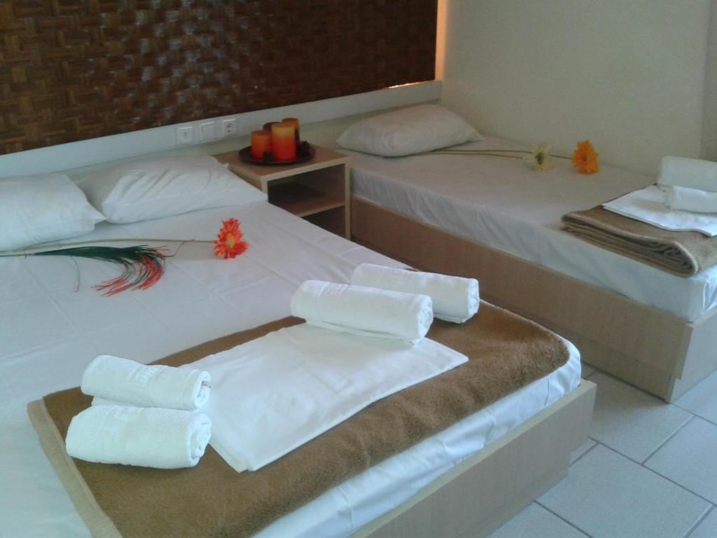 Dos camas en una habitación con toallas. en Pantheon Beach Hotel, en Olympiakí Aktí