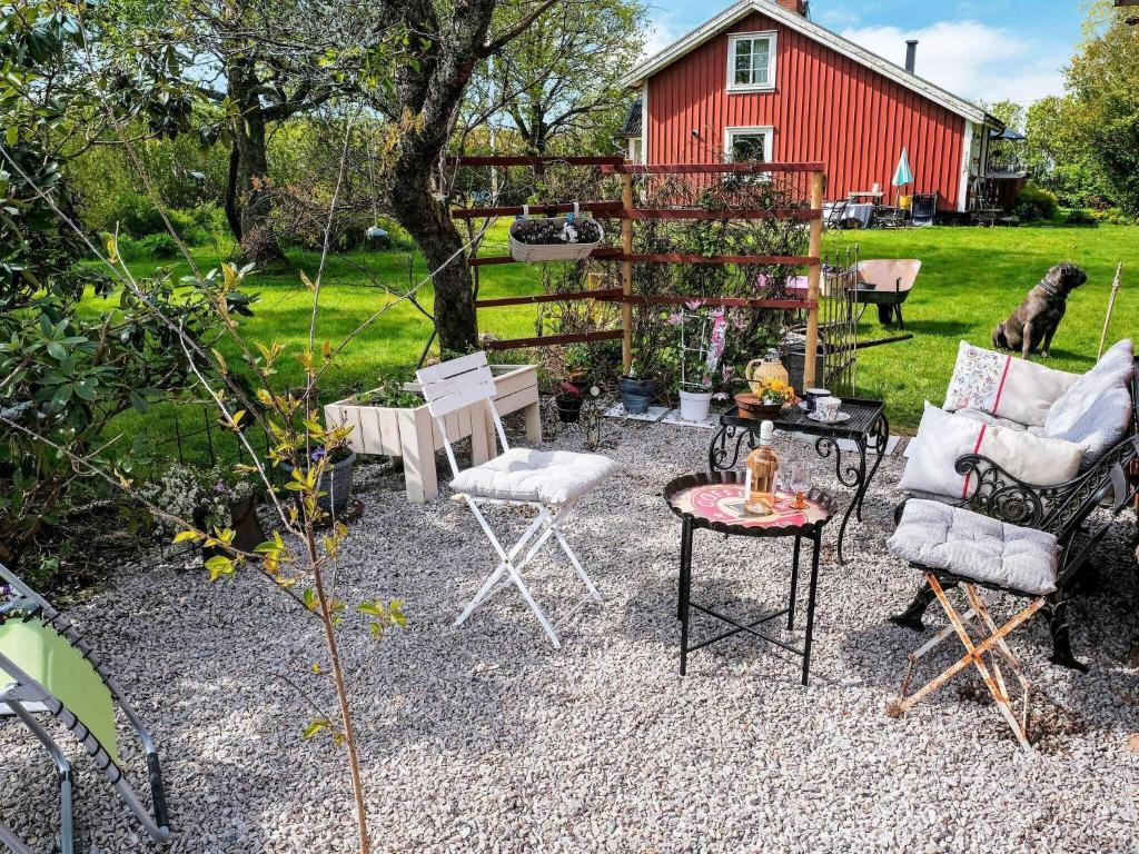 un patio con sillas, una mesa y un granero rojo en 5 person holiday home in TOSTARED, en Tostared